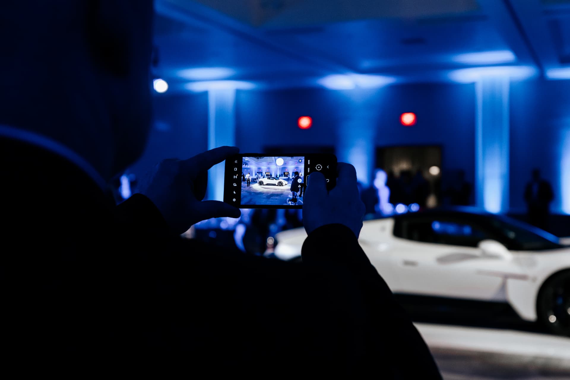 Guest filming a supercar reveal on a phone