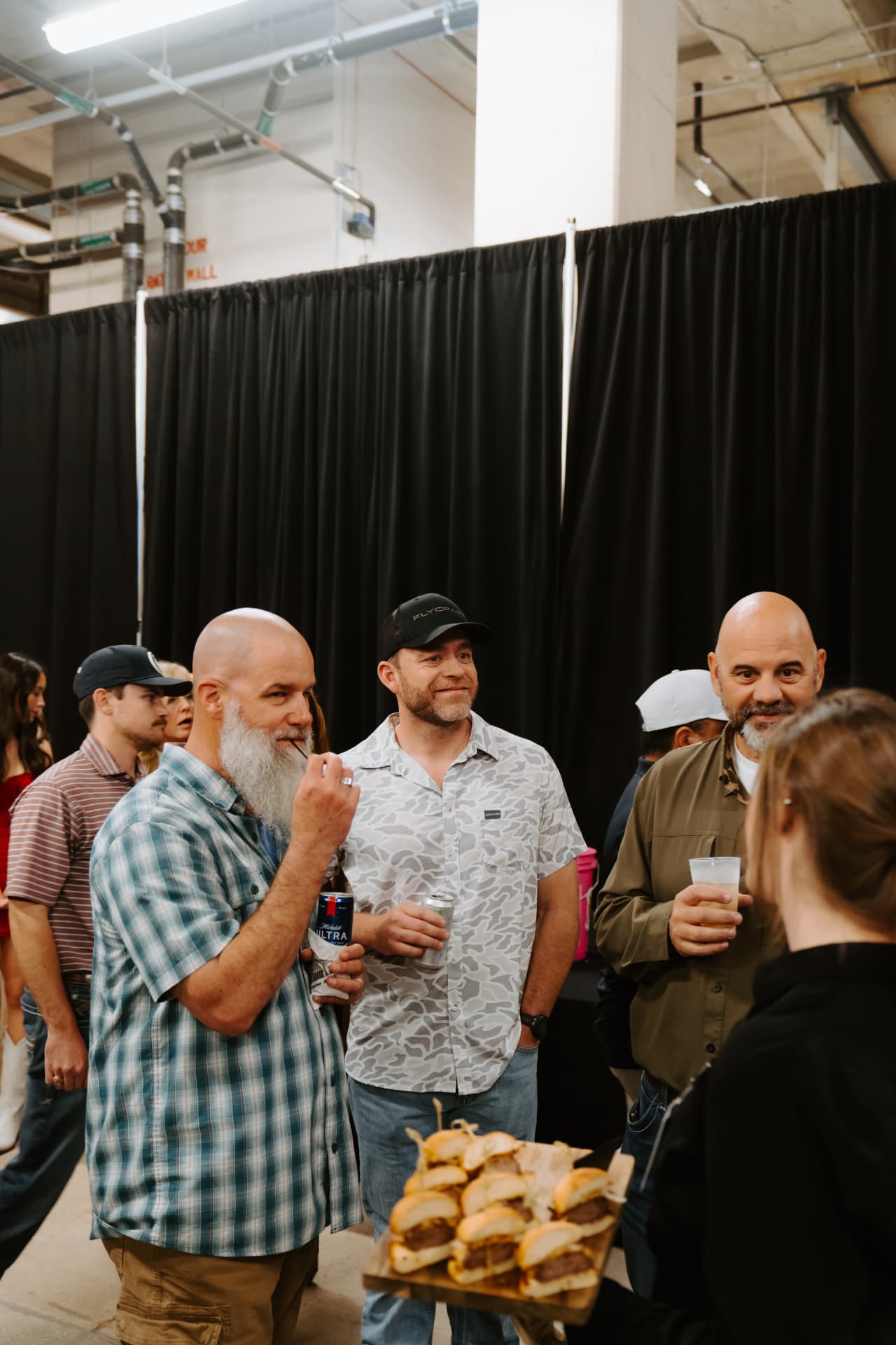 Guests with sliders and drinks at a club reception