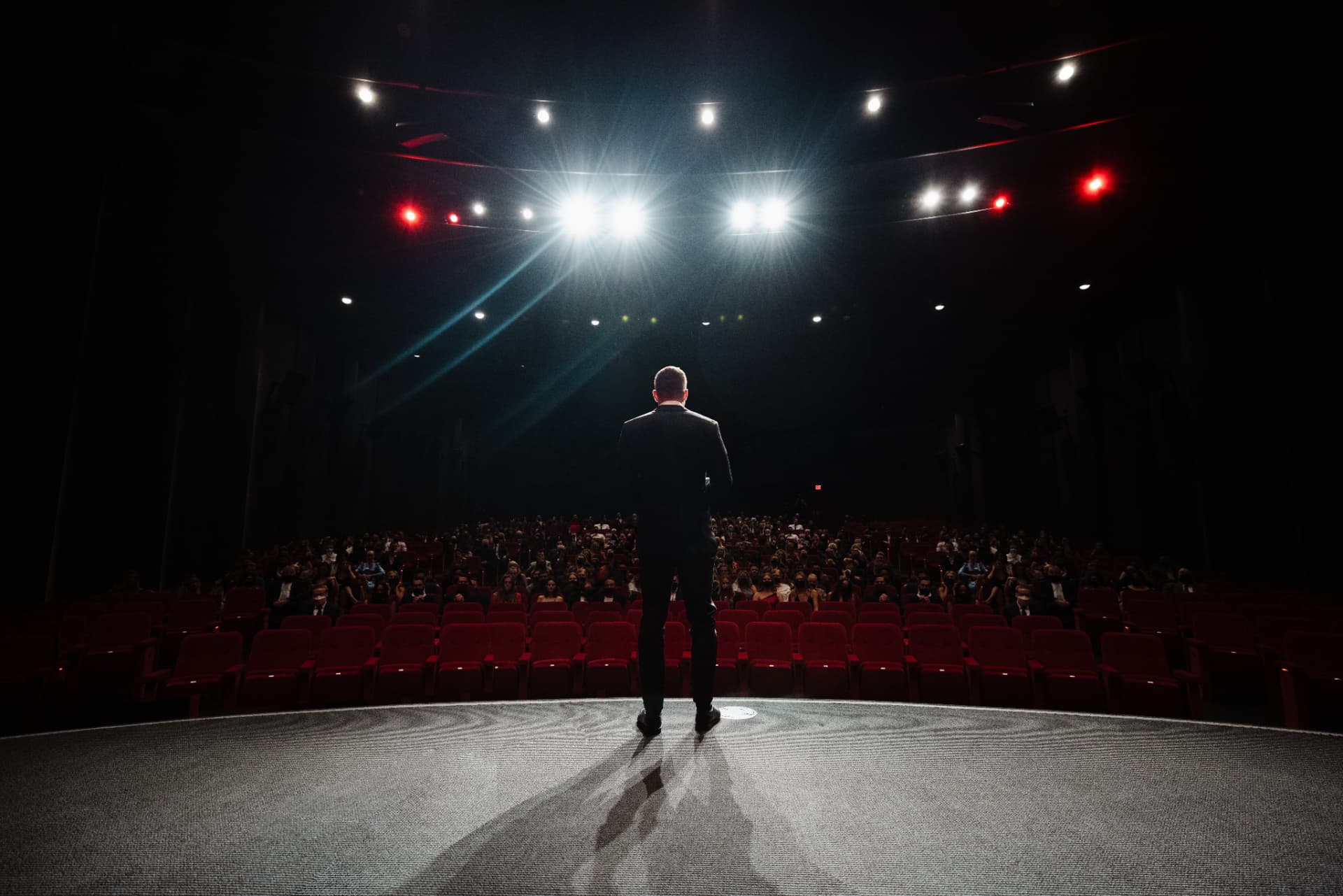 Speaker on stage in a packed theater