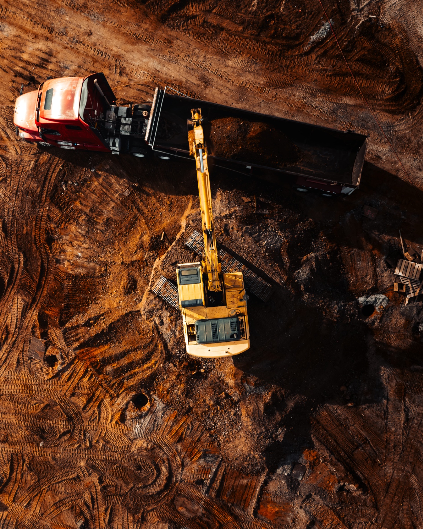 Aerial view of excavator loading truck on site