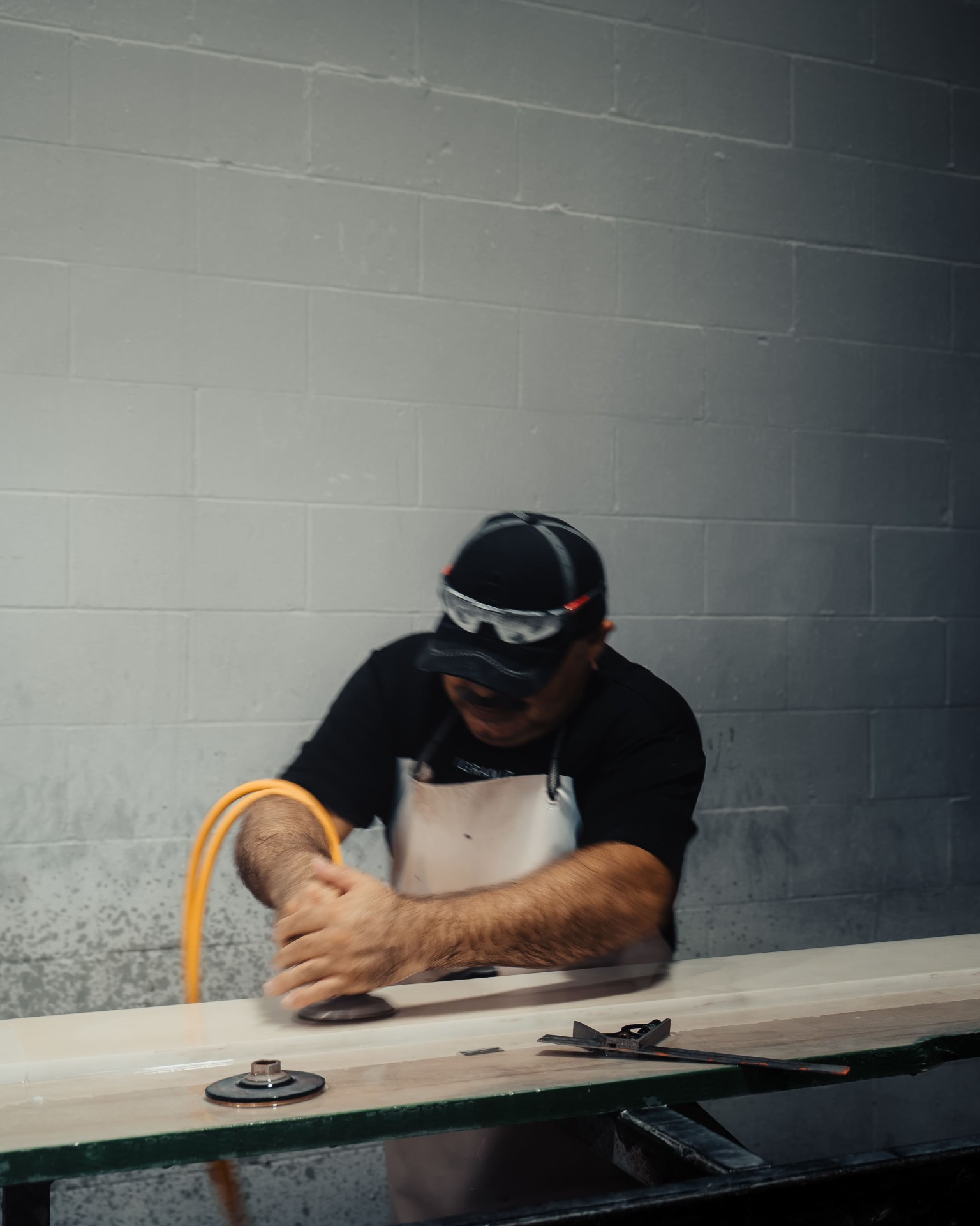 Stone fabricator polishing slab in workshop