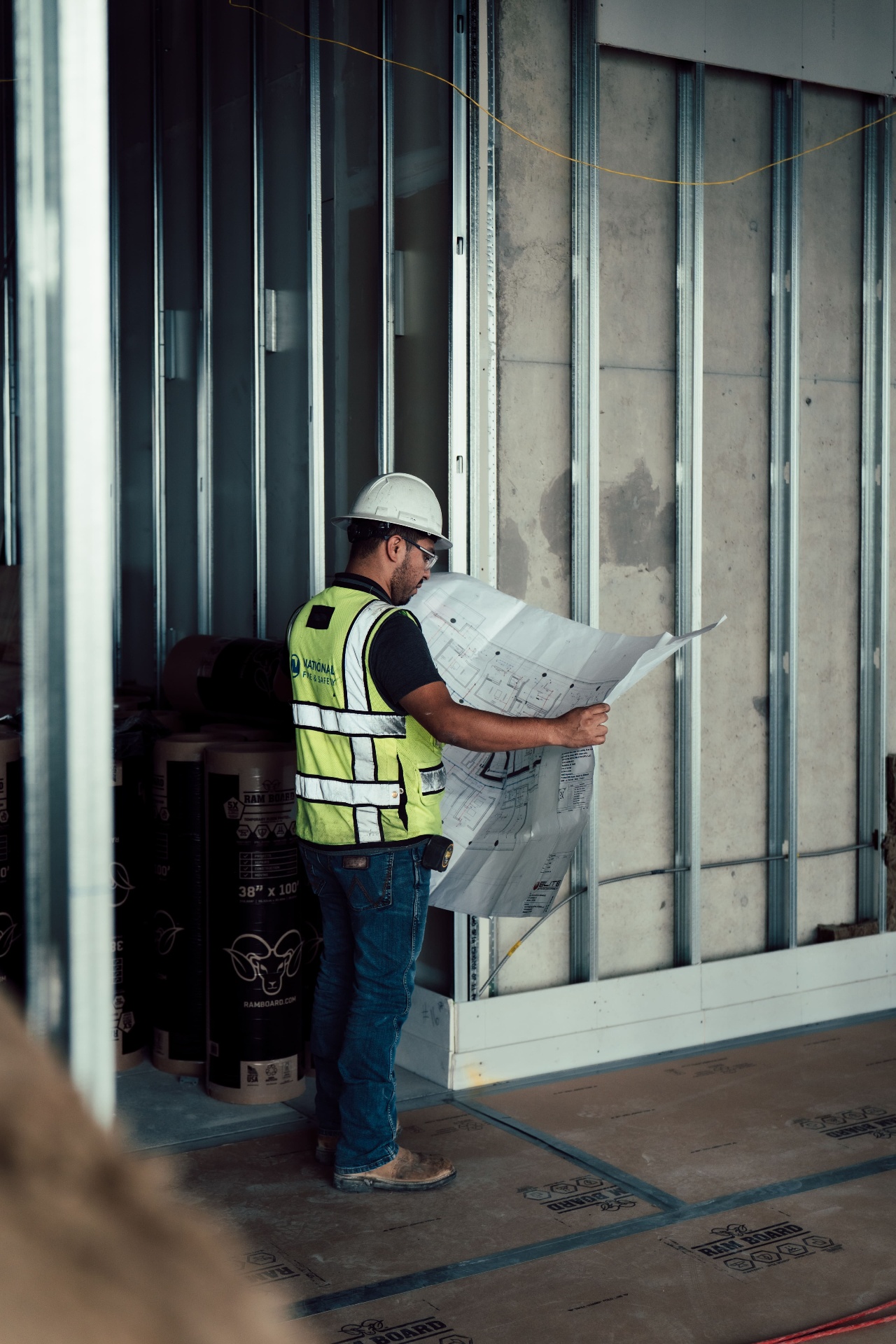 Worker reviewing plans inside framed interior
