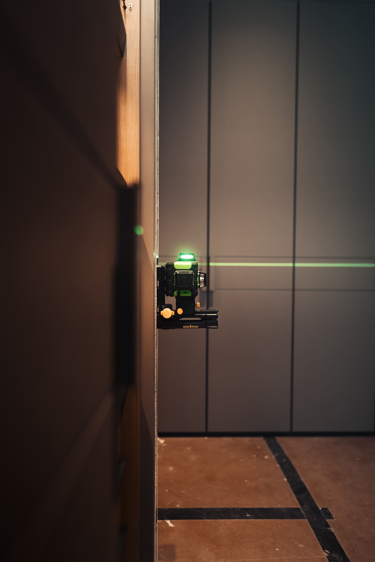 Green laser level on cabinetry wall during interior install