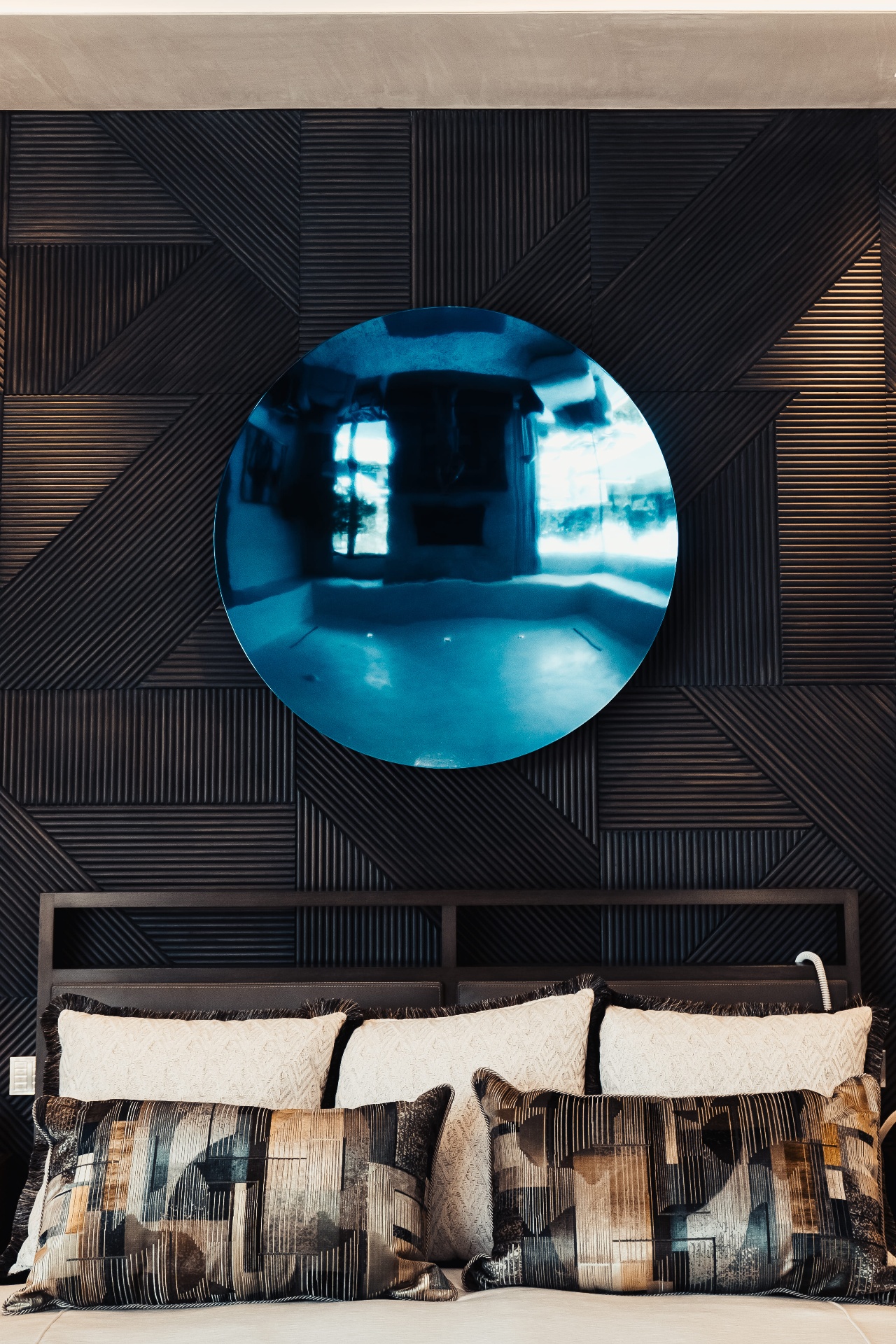 Bedroom with geometric wood wall and blue mirror