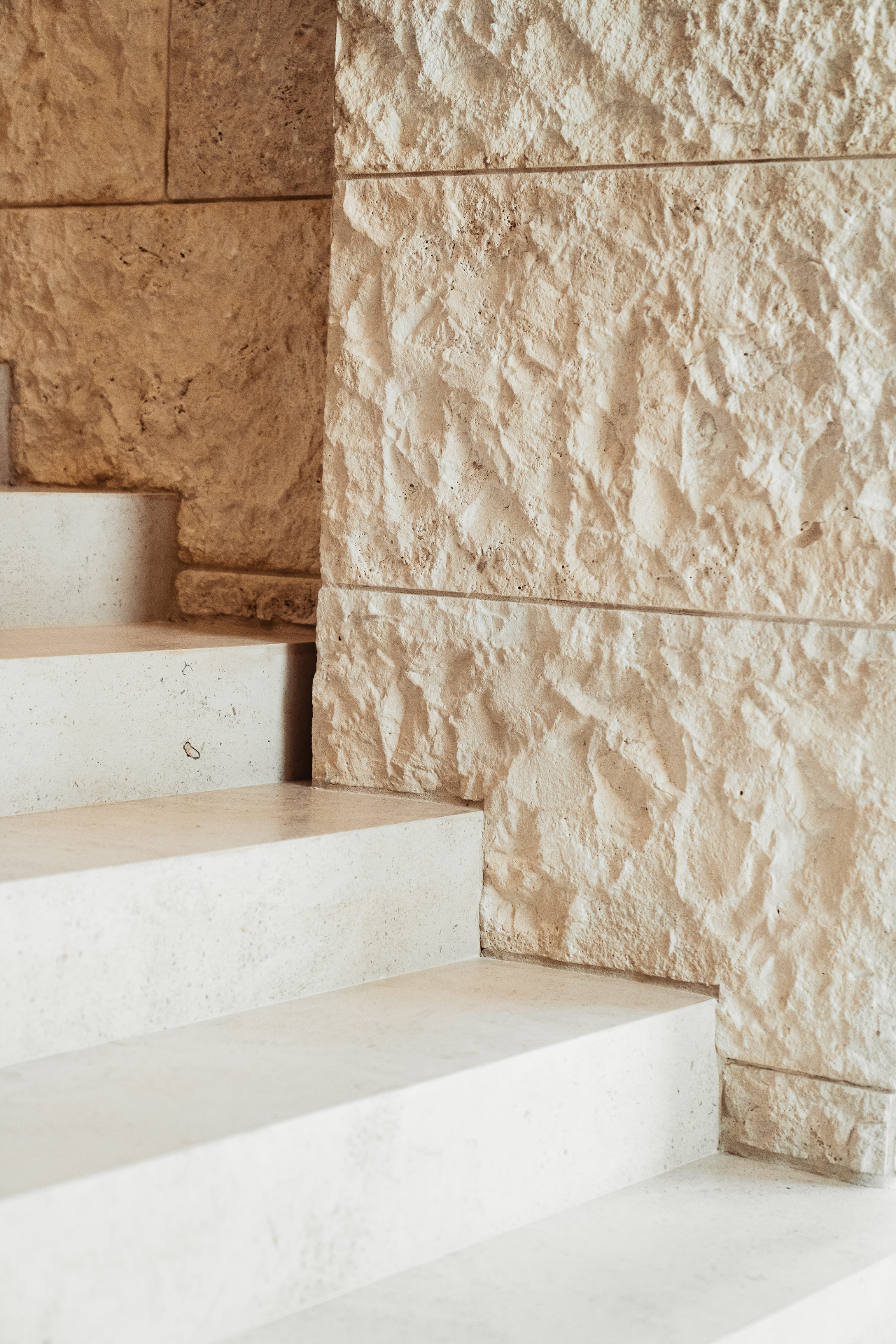 Limestone stairs with textured stone wall