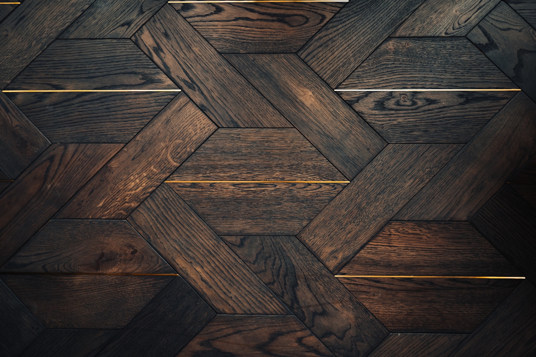 Custom geometric hardwood flooring with brass inlays