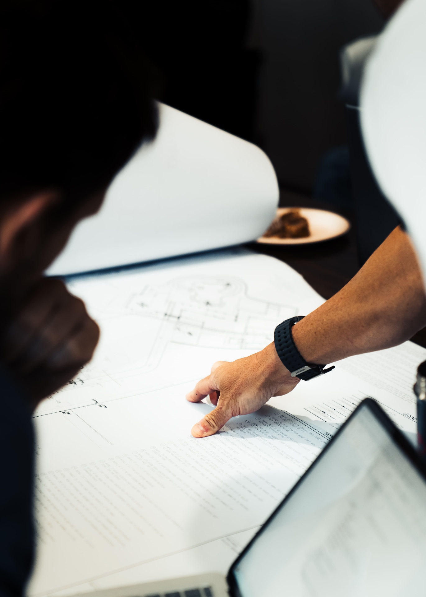 Team member reviewing architectural plans at desk