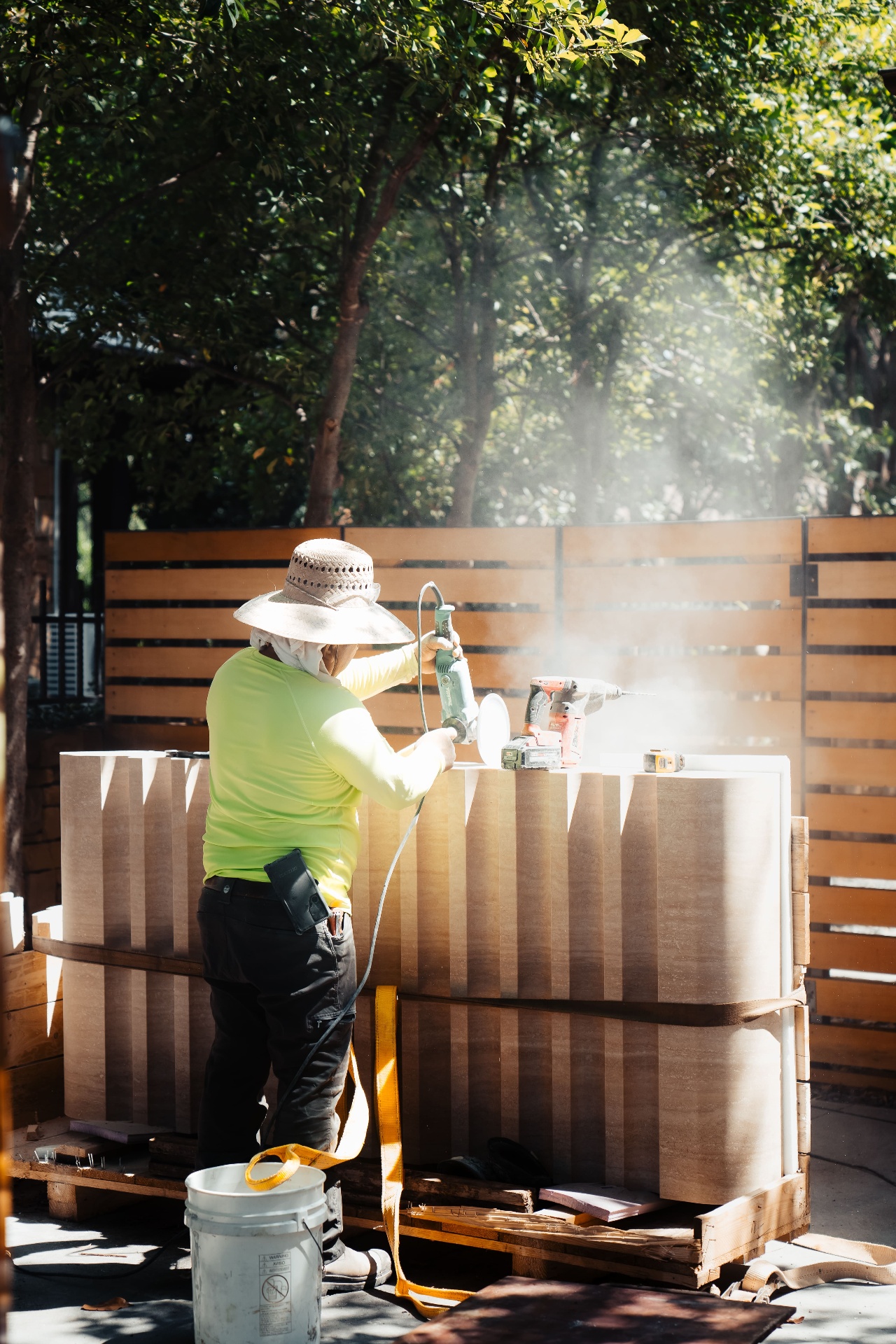Worker polishing travertine stone panels outdoors